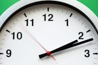 A close-up image of an analog clock face showing time with blurred motion