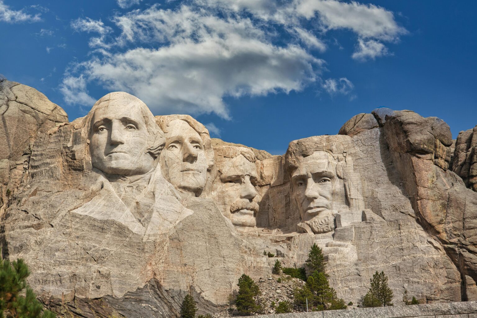 Iconic Mount Rushmore with presidential carvings in South Dakota under blue sky.